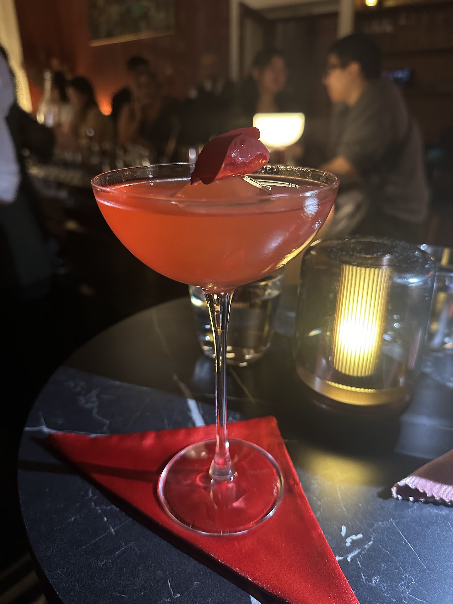 Two cocktails being served across the marble bar at Tailor Room