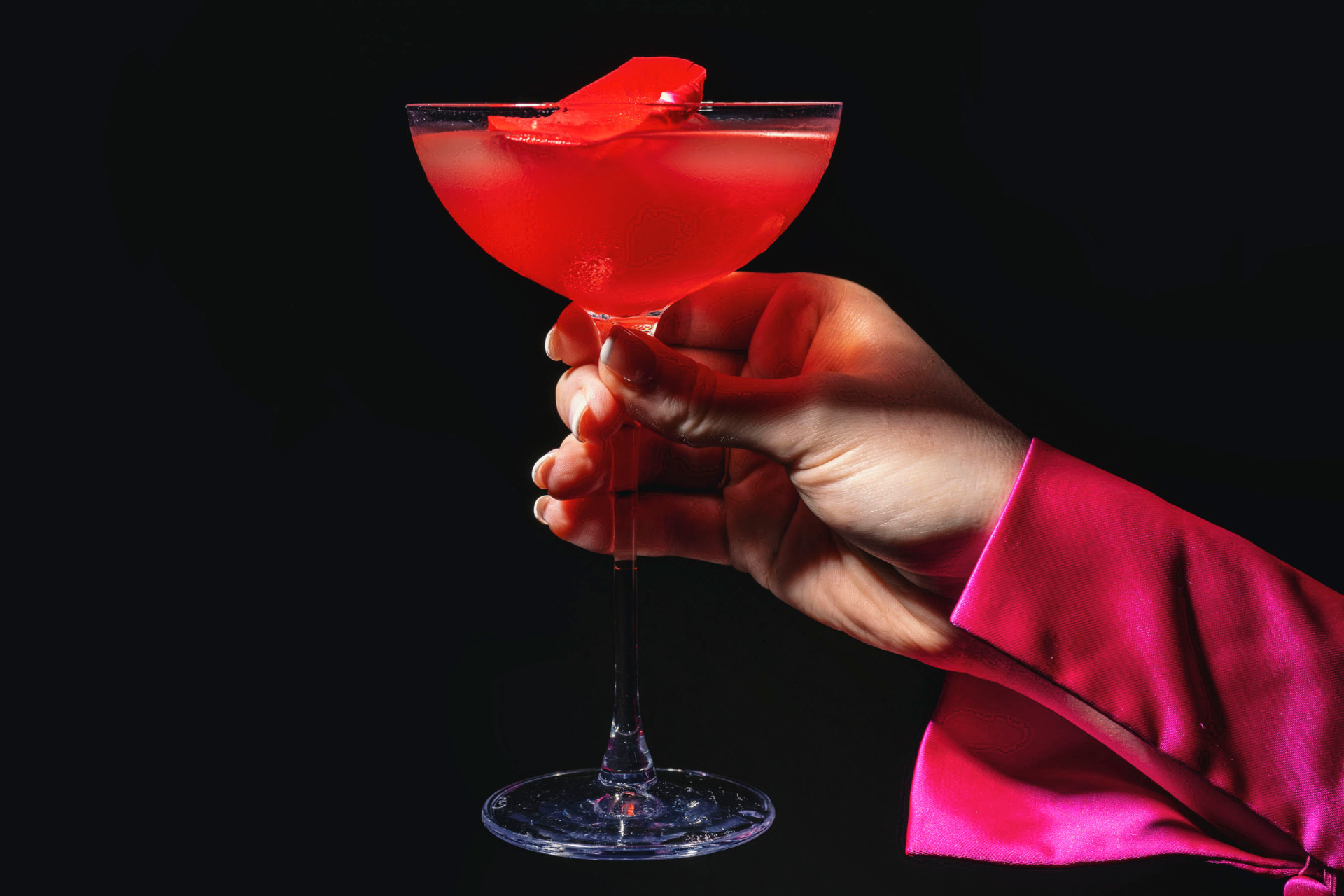 Red Tailor Room cocktail held against a dark background